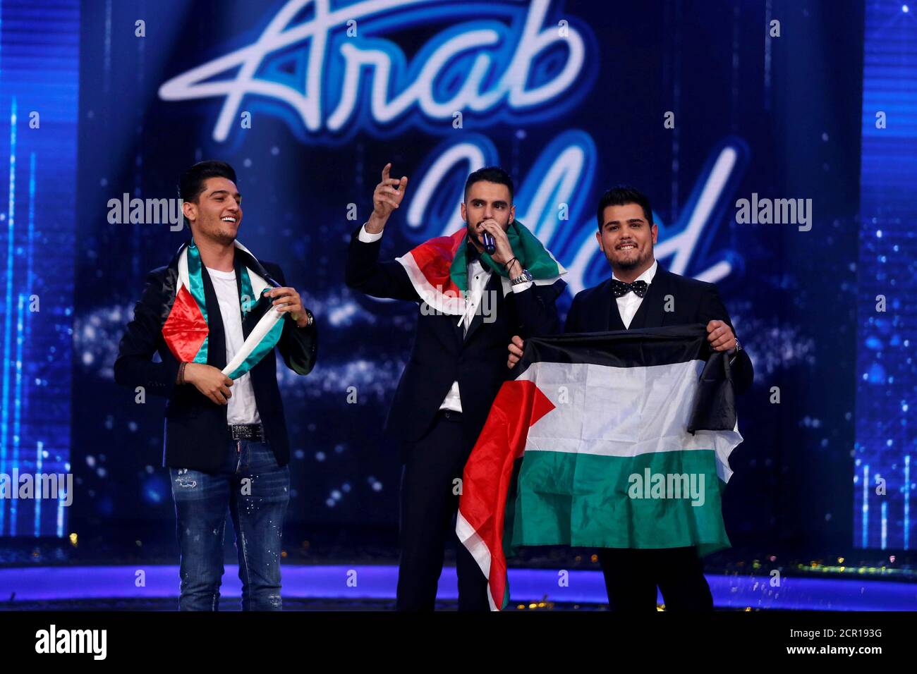 Palestinian Singer Yaqoub Shaheen C Winner Of Arab Idol Season 4 Performs As He Stands Next To Palestinian Contestant Singer Ameer Dandan R And Palestinian Singer Mohammed Assaf Winner Of The Second