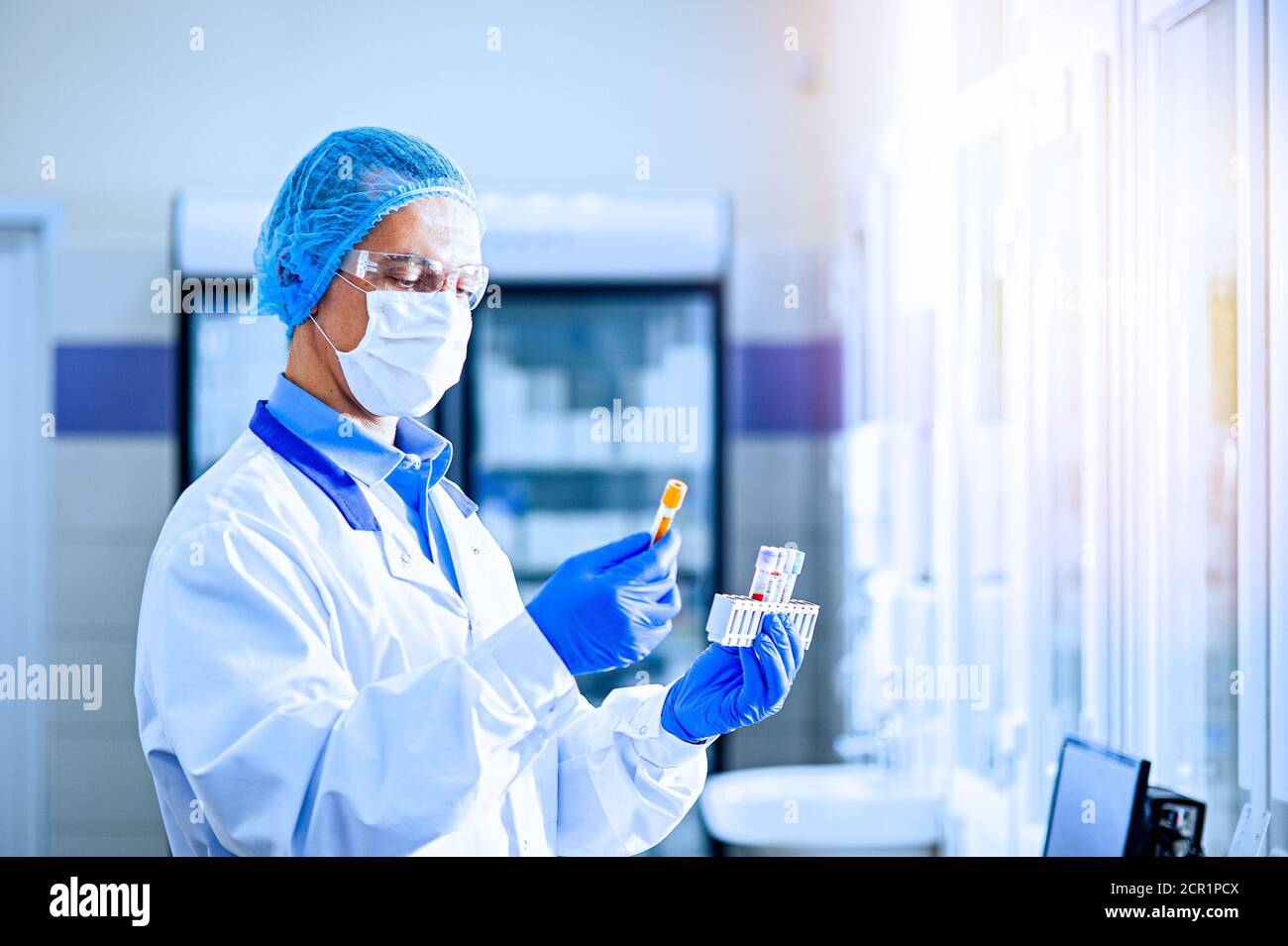 A medical worker, a laboratory assistant in a protective mask, visor