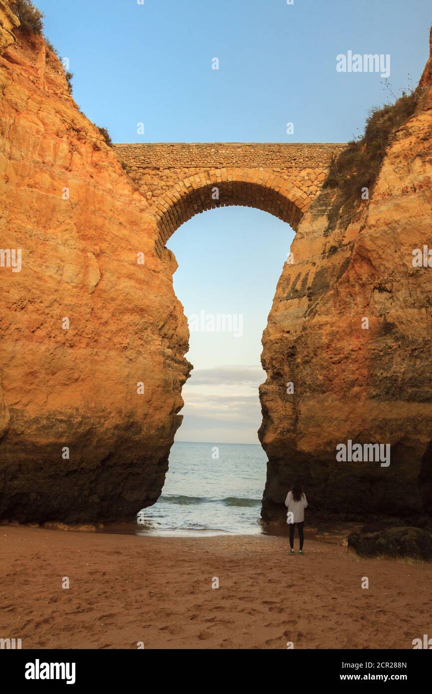 Praia dos Estudantes beach during Sunset with arch bridge in Lagos, Algarve, Portugal Stock Photo