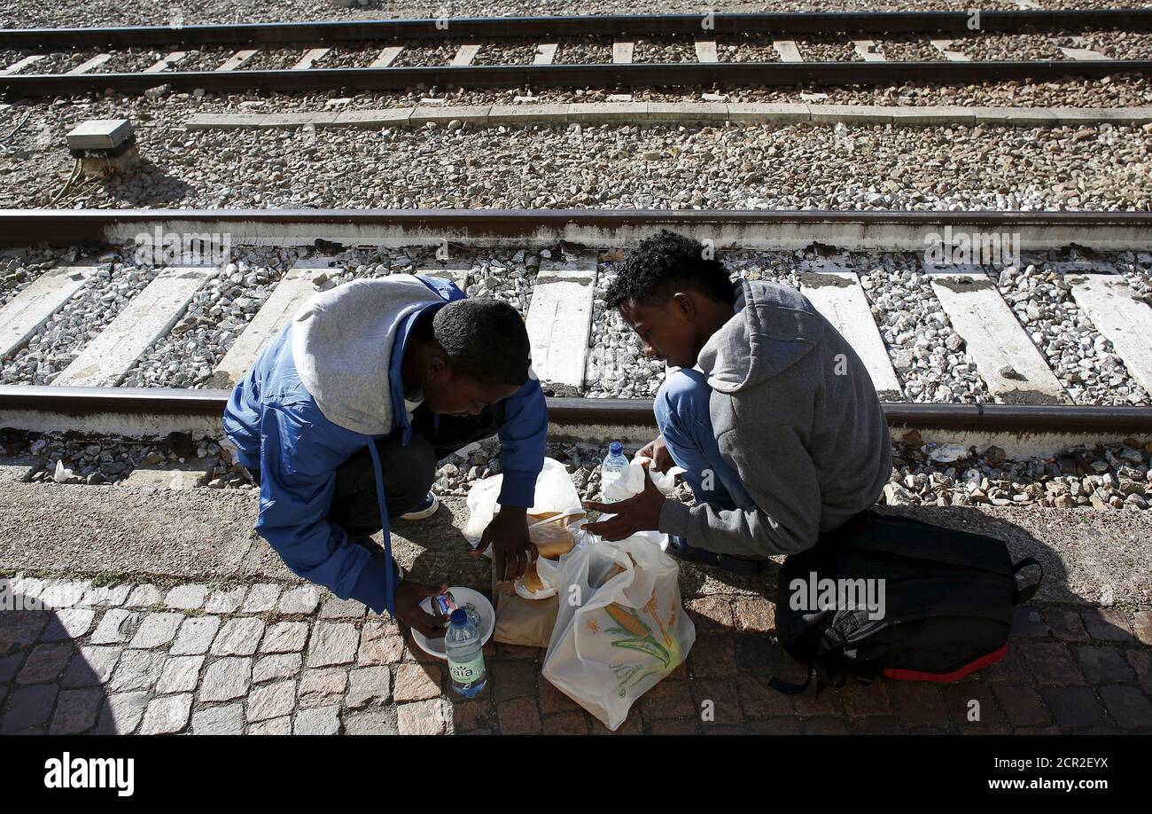 Migrants take a rest as they arrive at the Bolzano railway station, northern Italy, May 28, 2015. EU asylum rules, known as the Dublin Regulation, were first drafted in the early 1990s and require people seeking refuge to do so in the European country where they first set foot. Northern European countries defend the policy as a way to prevent multiple applications across the continent. Some are upset with what they see as Italy's lax attitude to registering asylum seekers. Earlier this year, French police stopped about 1,000 migrants near the border and returned them to Italy. Smaller round-up Stock Photo