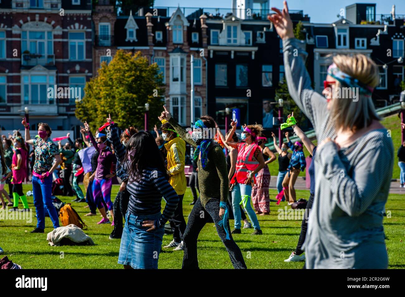 Activists are seen dancing while raising their hands during the rally.During the whole month, the climate activists group Extinction Rebellion in The Netherlands has planned a new campaign called 'September Rebellion' to draw attention to the climate and ecological crisis. At the Museumplein, in Amsterdam, hundreds of XR activists danced to demand action against climate change in what protesters dubbed “civil disco-bedience”. Activists waved flags and danced to songs including the Bee Gees’ 1977 hit, Stayin’ Alive. After the Museumplein the activists blocked for a few minutes one of the most i Stock Photo