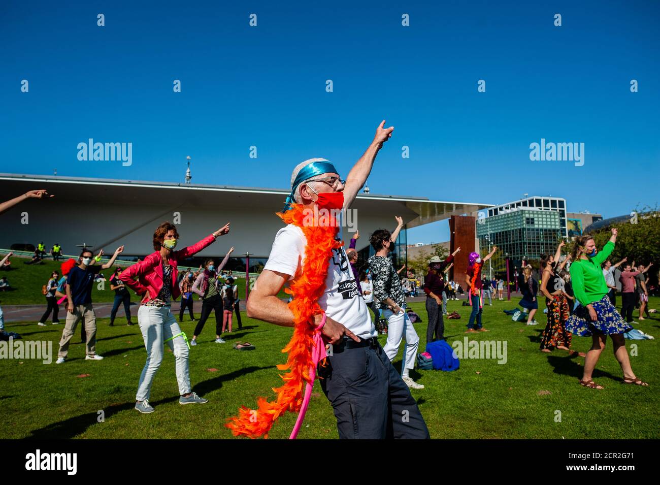 Activists are seen dancing while raising their hands during the rally.During the whole month, the climate activists group Extinction Rebellion in The Netherlands has planned a new campaign called 'September Rebellion' to draw attention to the climate and ecological crisis. At the Museumplein, in Amsterdam, hundreds of XR activists danced to demand action against climate change in what protesters dubbed “civil disco-bedience”. Activists waved flags and danced to songs including the Bee Gees’ 1977 hit, Stayin’ Alive. After the Museumplein the activists blocked for a few minutes one of the most i Stock Photo