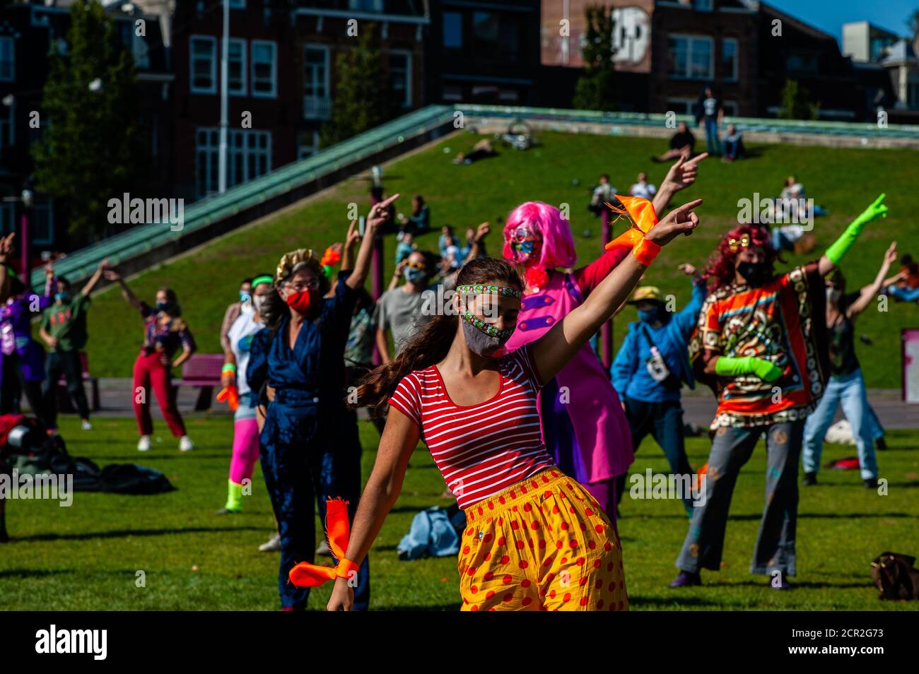 Activists are seen dancing while raising their hands during the rally.During the whole month, the climate activists group Extinction Rebellion in The Netherlands has planned a new campaign called 'September Rebellion' to draw attention to the climate and ecological crisis. At the Museumplein, in Amsterdam, hundreds of XR activists danced to demand action against climate change in what protesters dubbed “civil disco-bedience”. Activists waved flags and danced to songs including the Bee Gees’ 1977 hit, Stayin’ Alive. After the Museumplein the activists blocked for a few minutes one of the most i Stock Photo