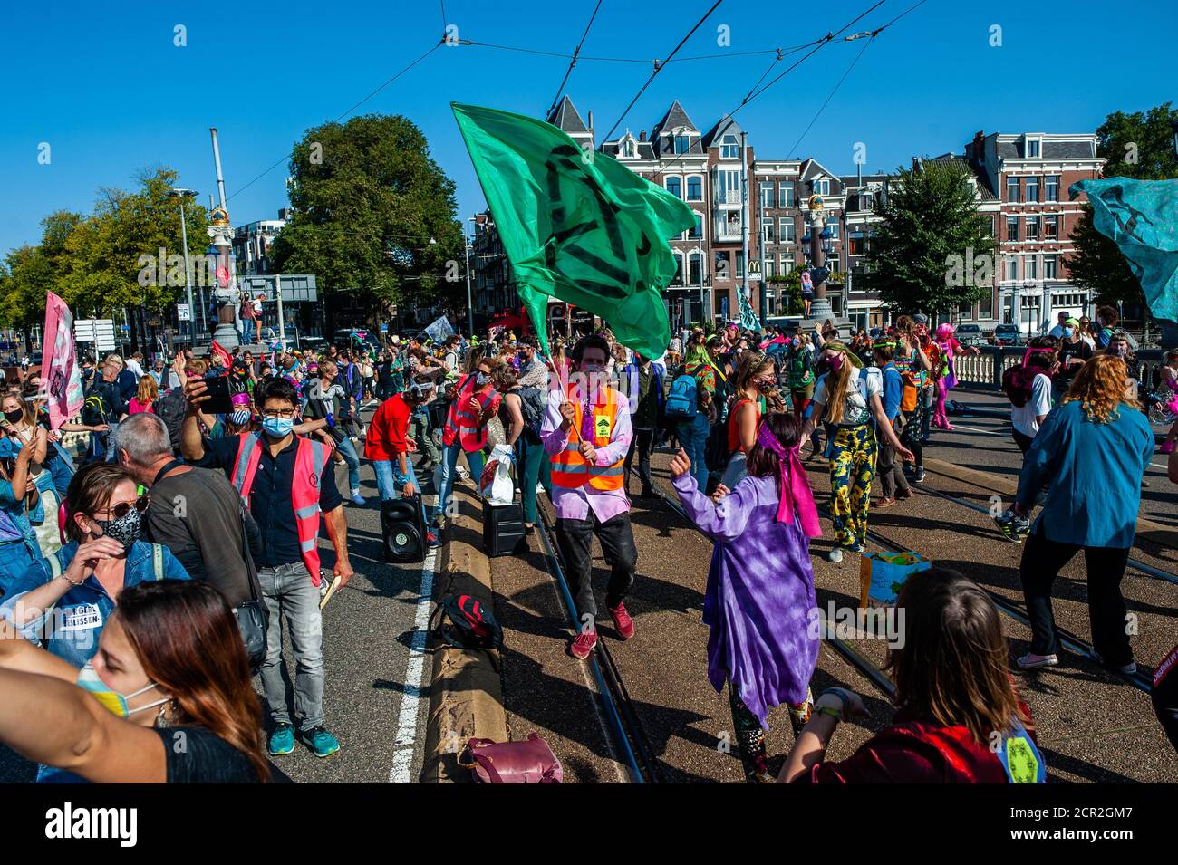 Activists are seen dancing in the middle of the bridge during the rally.During the whole month, the climate activists group Extinction Rebellion in The Netherlands has planned a new campaign called 'September Rebellion' to draw attention to the climate and ecological crisis. At the Museumplein, in Amsterdam, hundreds of XR activists danced to demand action against climate change in what protesters dubbed “civil disco-bedience”. Activists waved flags and danced to songs including the Bee Gees’ 1977 hit, Stayin’ Alive. After the Museumplein the activists blocked for a few minutes one of the most Stock Photo