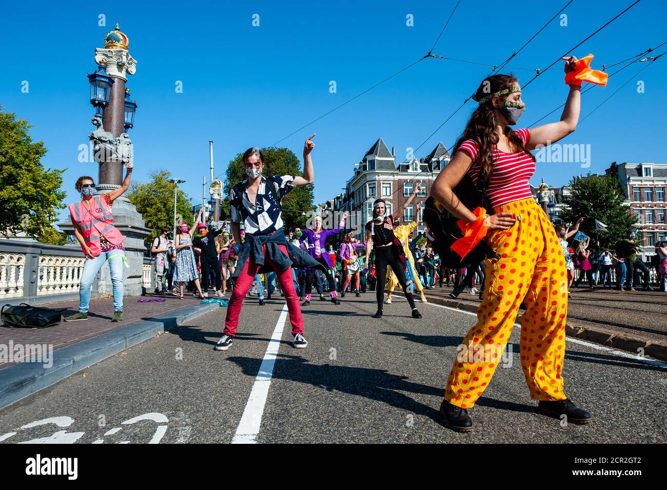 A group of climate activists are seen dancing during the rally.During the whole month, the climate activists group Extinction Rebellion in The Netherlands has planned a new campaign called 'September Rebellion' to draw attention to the climate and ecological crisis. At the Museumplein, in Amsterdam, hundreds of XR activists danced to demand action against climate change in what protesters dubbed “civil disco-bedience”. Activists waved flags and danced to songs including the Bee Gees’ 1977 hit, Stayin’ Alive. After the Museumplein the activists blocked for a few minutes one of the most importan Stock Photo
