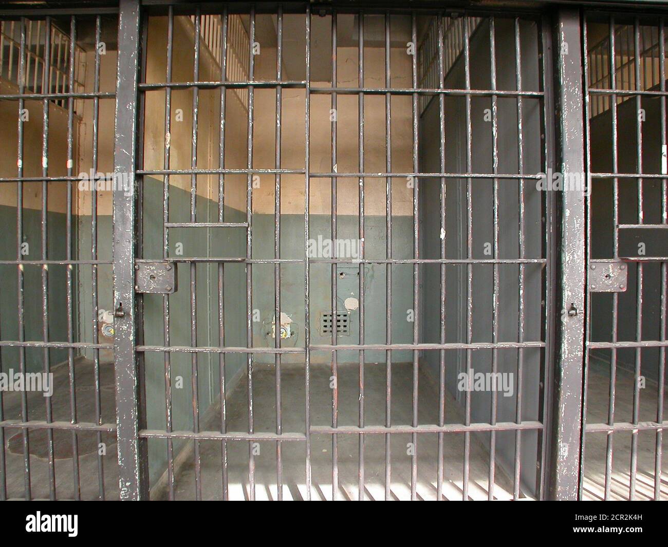 View bare empty jail cell block in an old rundown government owned facility. Stock Photo