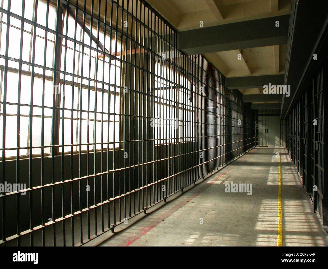 View towards bars and windows inside cell block inside old unused government city jail facility. Stock Photo