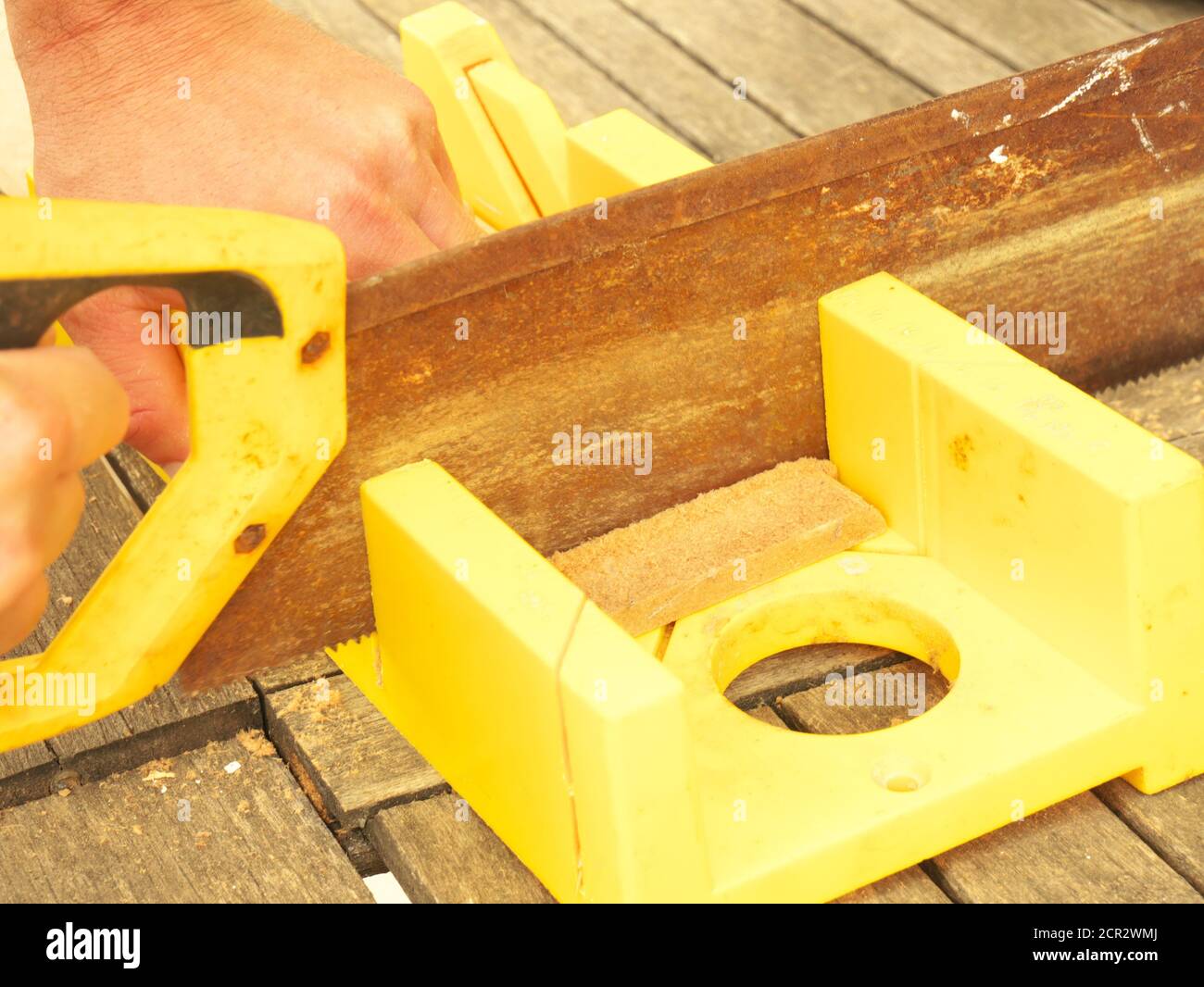 Close up on the hands of a man cutting timber with a saw Stock Photo