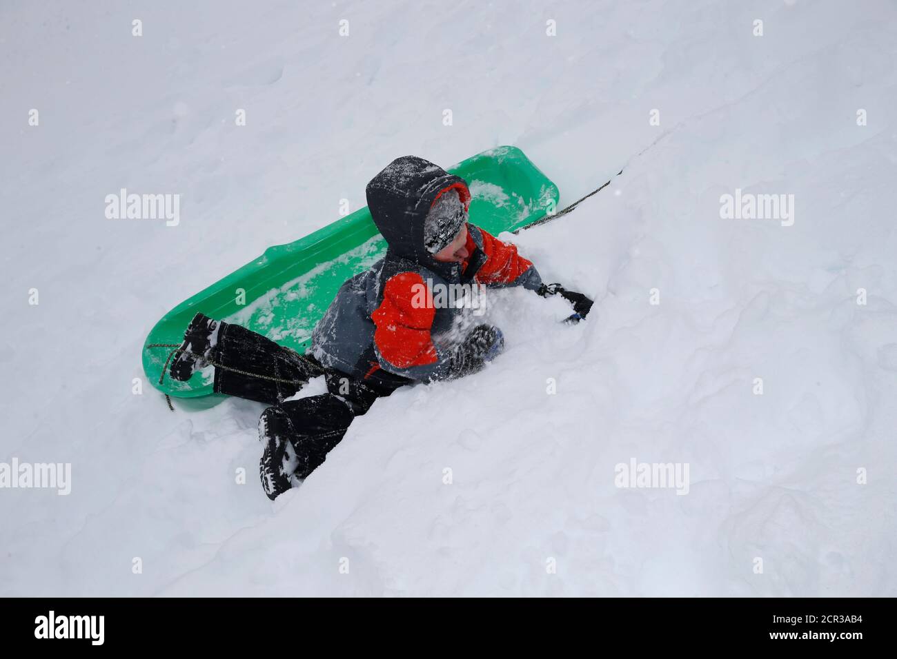 A child plays on the snow-covered grounds of the U.S.Capitol in Washington January 23, 2016. Thick snow covered the Washington, D.C. area on Saturday as a potentially record-breaking blizzard paralyzed road, rail and airline travel on the U.S. East Coast from North Carolina to New York. REUTERS/Jonathan Ernst Stock Photo