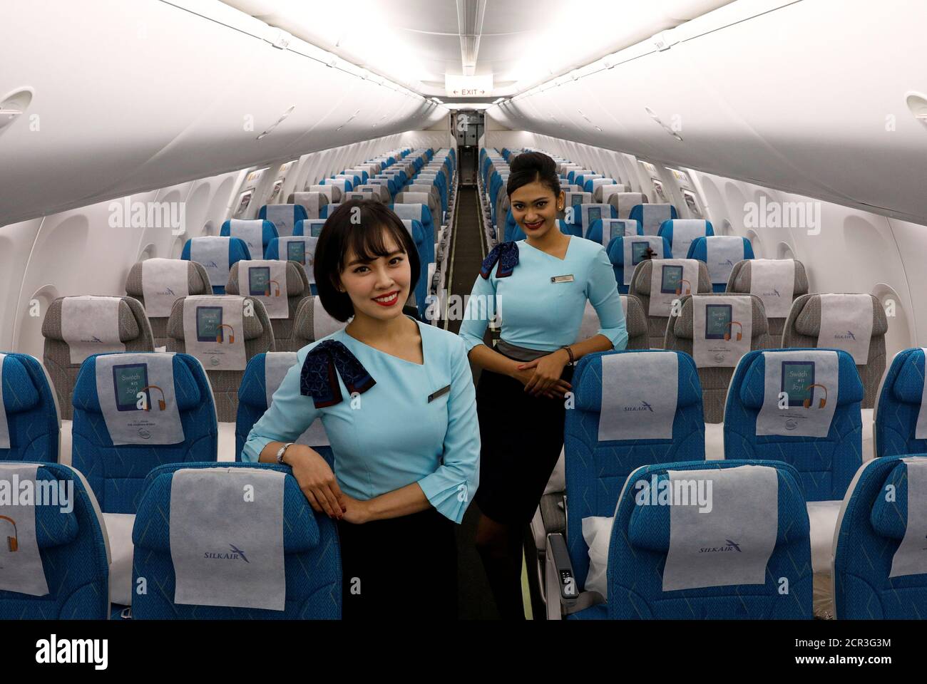 Stewardesses pose in the economy class cabin during a tour of SilkAir's new aircraft, the Boeing 737 Max 8 at Changi Airport in Singapore October 4, 2017. REUTERS/Edgar Su Stock Photo