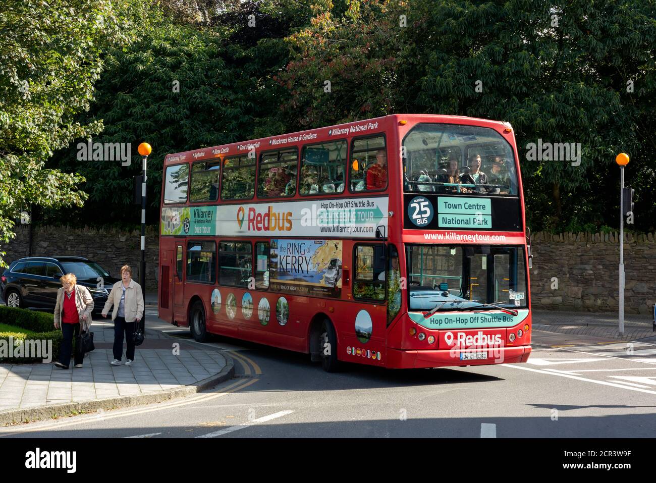Killarney Ireland hop on hop off seasonal double decker tourist sightseeing red bus on the streets on sunny day as local popular tourist activity. Stock Photo