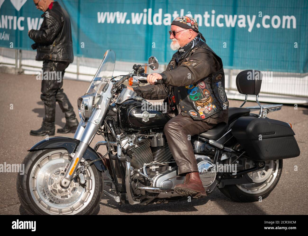 Full size lone senior Harley Davidson rider biker in brown leather jacket and pants riding slowly at the 'Harley Davidson' Bike Fest Killarney Ireland Stock Photo