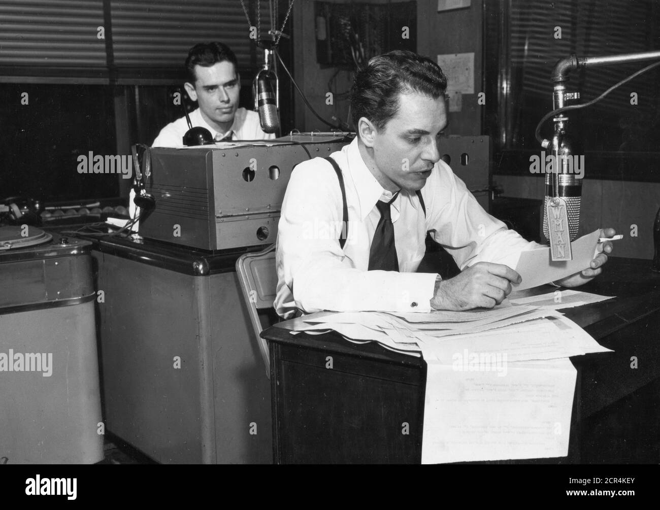 In the control room of a small Ohio radio station, an announcer is shown broadcasting returns as fast as he gets them from national news wireservices and local tabulators, Mansfield, Ohio, 11/02/1948. (Photo by RBM Vintage Images) Stock Photo