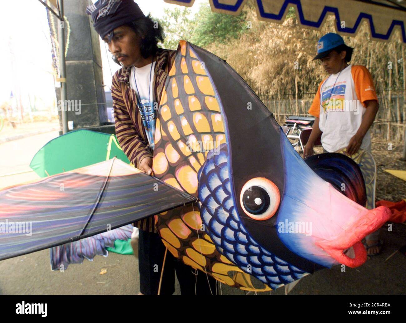 Indonesian men prepare a kite shaped like a fish for a kite festival in Jakarta on June 28, 2002. The men are among dozens of international participants at Jakarta's international kite festival. Eleven countries and dozens of provinces in Indonesia will take part in the three-day festival. REUTERS/Supri DW/CP Stock Photo