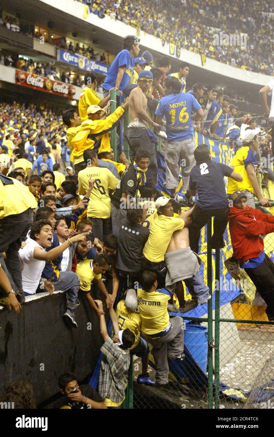 Rowdy fans of Mexican club America stand in the sunken division between the  stands and field during disturbances which followed America's Copa  Libertadores match against Brazil's Sao Caetano at Mexico City's Azteca