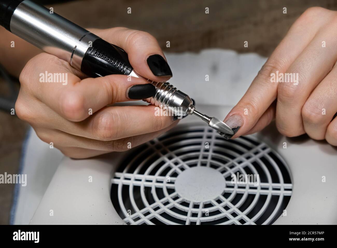 Hardware manicure in beauty salon or home. Manicurist is applying electric nail  file drill to manicure on female fingers. Mechanical manicure close-up  Stock Photo - Alamy
