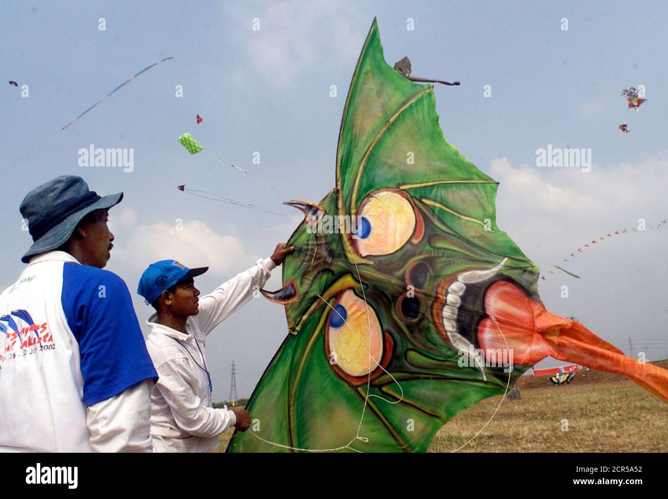 Indonesian participants prepare to fly a kite shaped like a monster's face in Jakarta June 30, 2002. The men are among dozens of international participants at Jakarta's international Kite festival. Eleven countries and dozens of provinces in Indonesia will take part in the three-day festival. REUTERS/Supri AS Stock Photo
