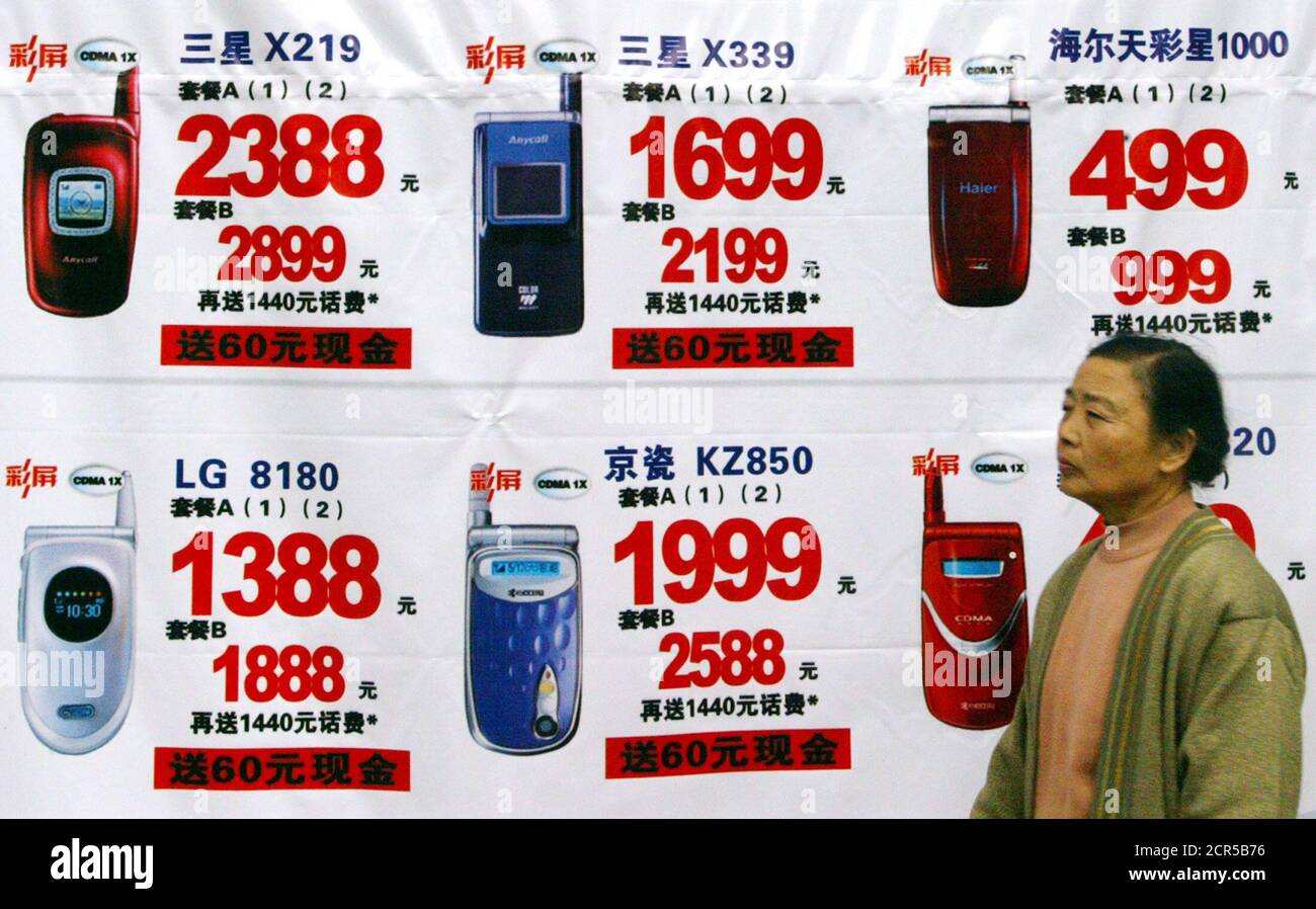 A Chinese shopper walks past mobile phone promotion poster in Shanghai  November 26, 2003. China's mobile phone users grew by 50.93 million in the  first 10 months of 2003 to 256.94 million,