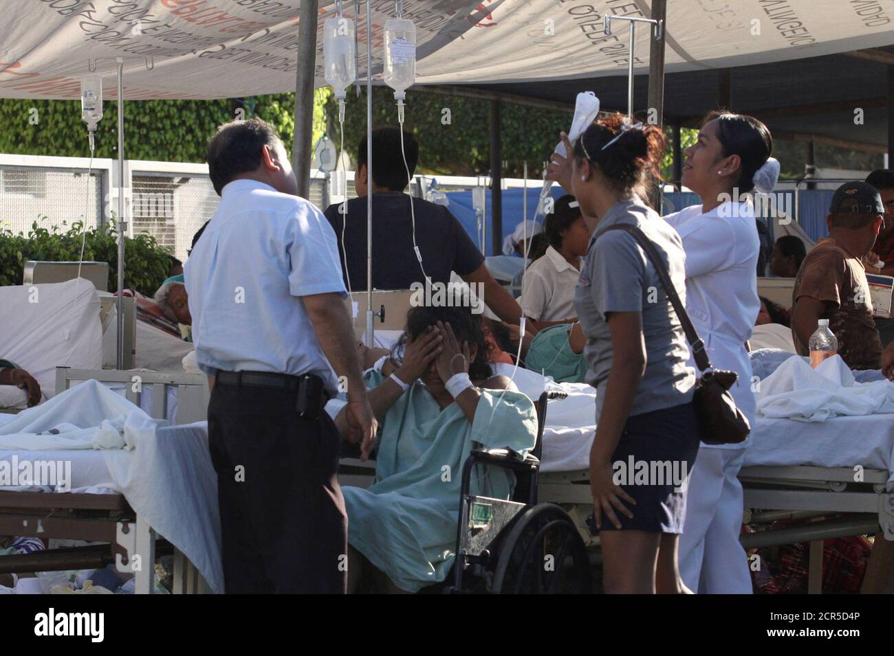 A patient in a wheelchair is attended to by a nurse at a makeshift emergency room after being evacuated from a hospital damaged by an earthquake on Tuesday in Ometepec in the Mexican state of Guerrero March 20, 2012. The 7.4-magnitude quake hit hardest in the southwestern state of Guerrero, where around 800 houses were damaged, officials said. The state governor Angel Aguirre said he had reports of homes being knocked down, though state authorities could not confirm this. REUTERS/Jacob Garcia (MEXICO - Tags: DISASTER) Stock Photo