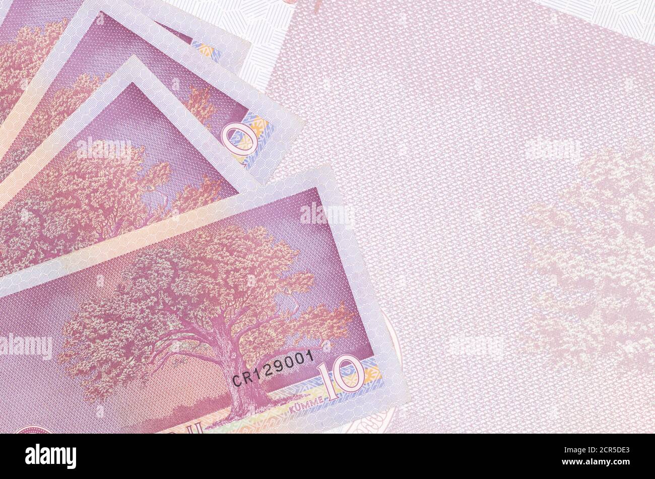 10 Estonian kroon bills lies in stack on background of big semi-transparent banknote. Abstract business background with copy space Stock Photo