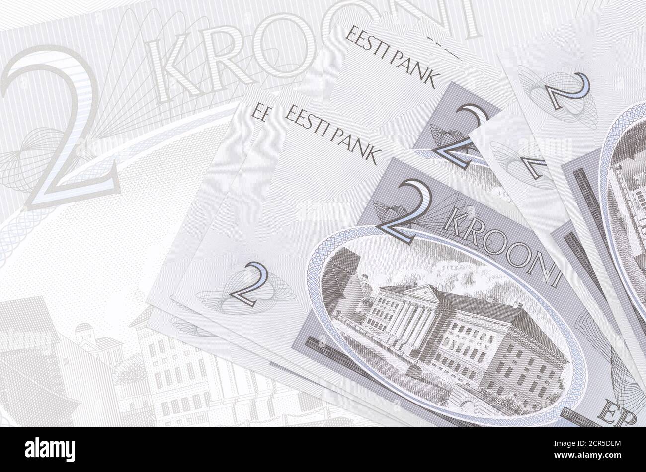 2 Estonian kroon bills lies in stack on background of big semi-transparent banknote. Abstract presentation of national currency. Business concept Stock Photo