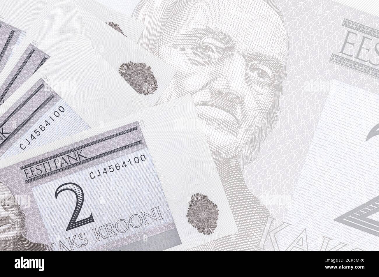 2 Estonian kroon bills lies in stack on background of big semi-transparent banknote. Abstract business background with copy space Stock Photo