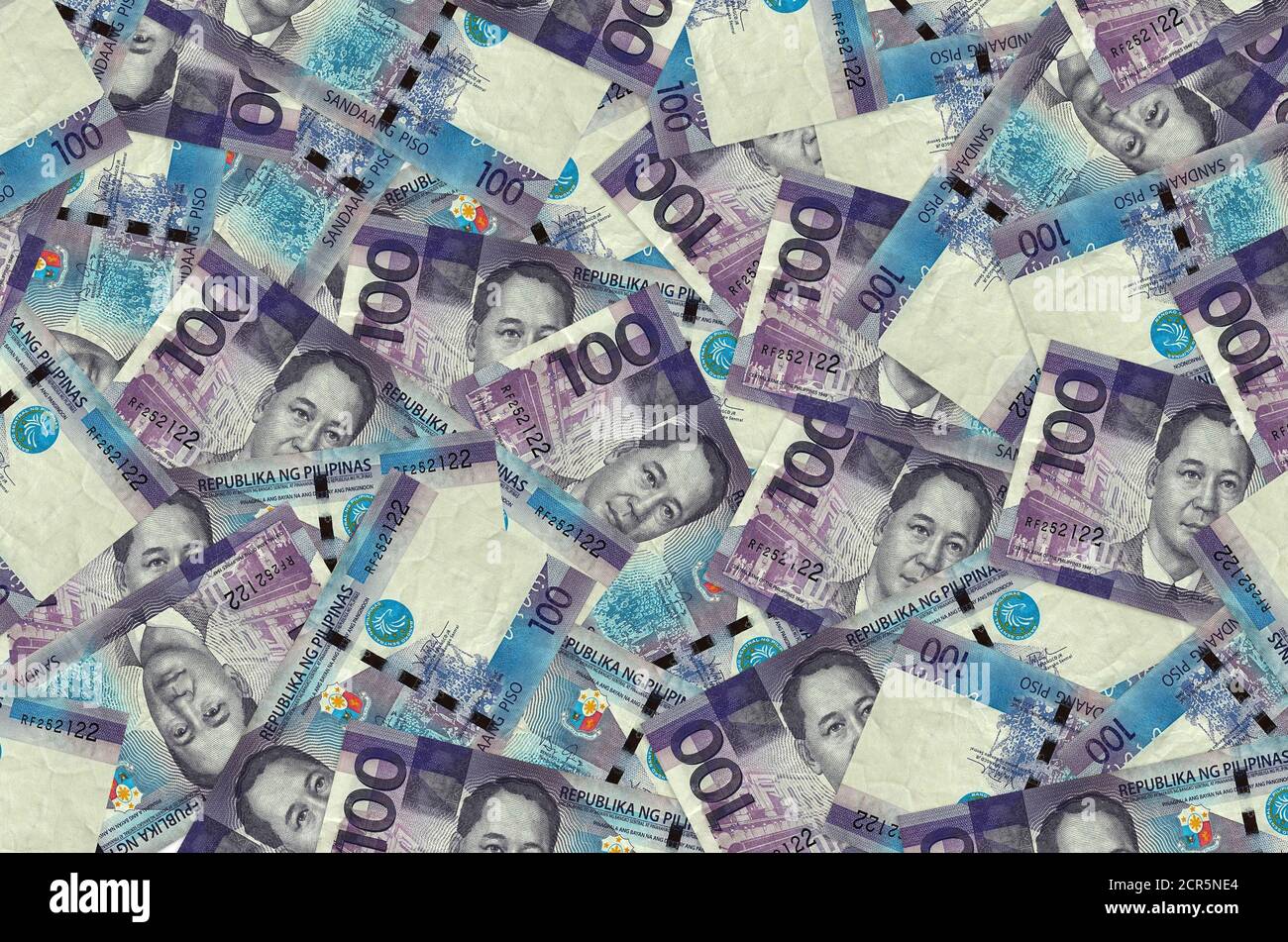 100 Philippine piso bills lies in big pile. Rich life conceptual background. Big amount of money Stock Photo