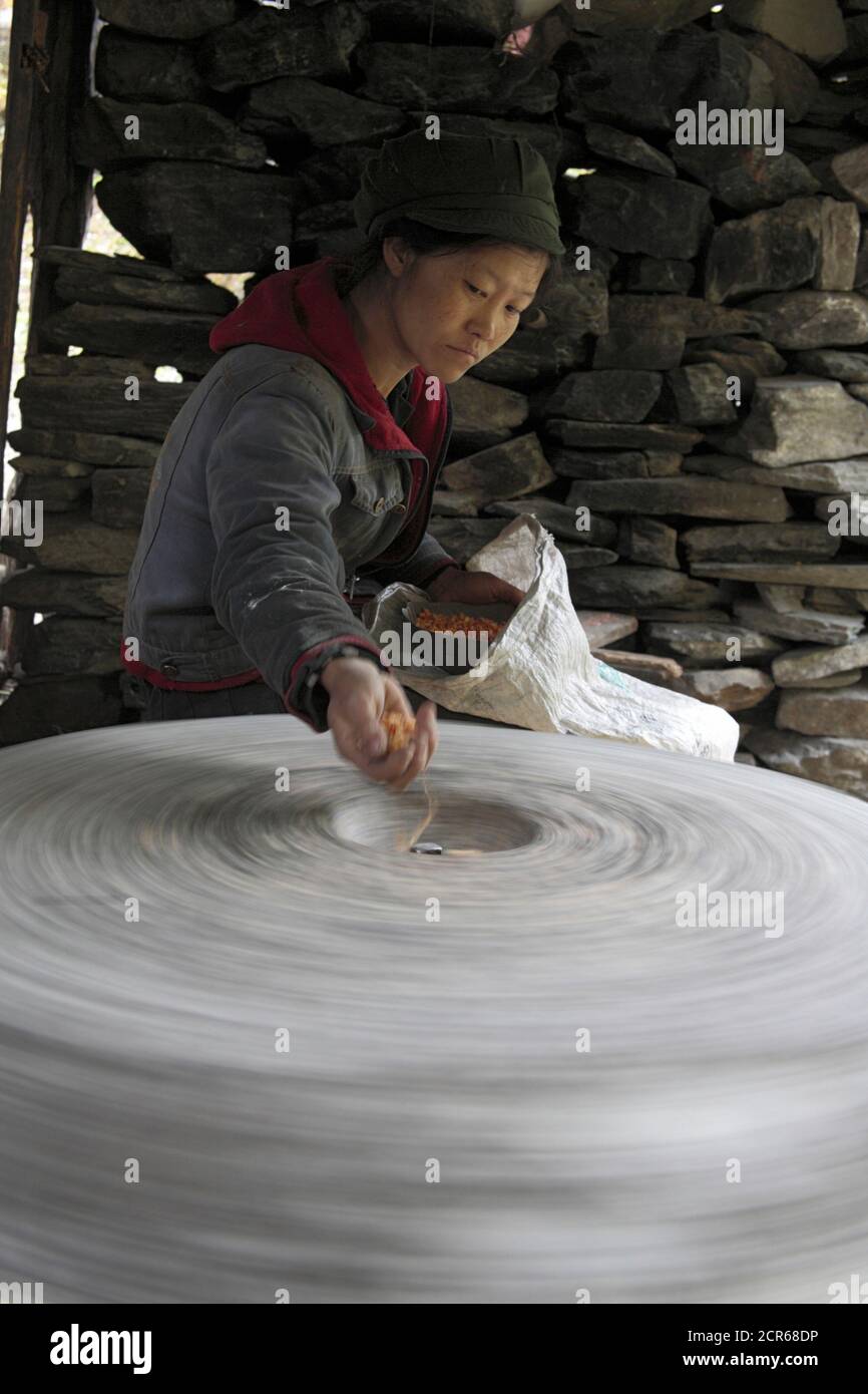 Corn grinding on waterpowered stone near Salween River, Yunnan