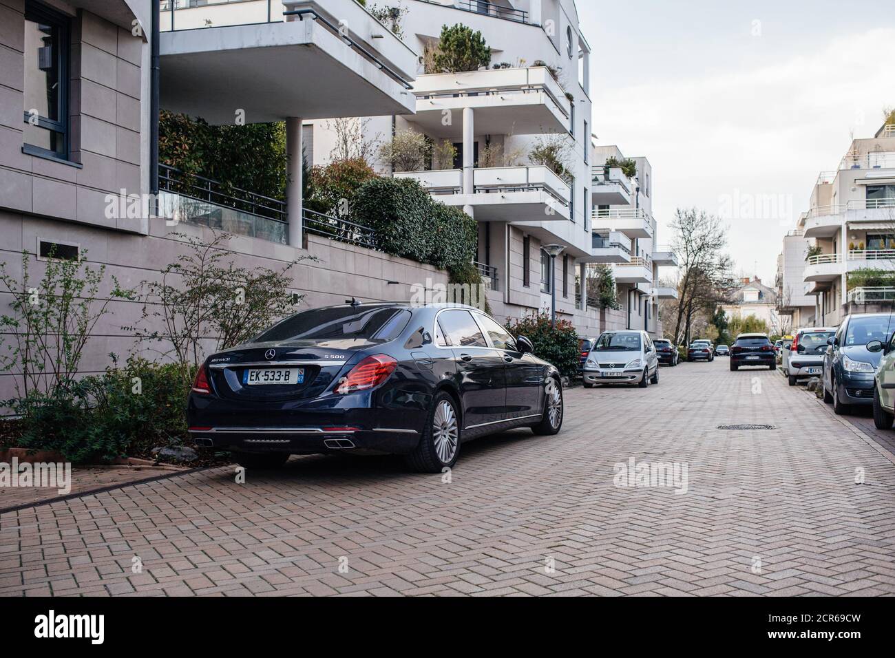 Strasbourg, France - Apr 8, 2018: Rear view of new luxury Mercedes-Benz Maybach S500 limousine parked on a large street with multiple apartment buildings perspective view Stock Photo