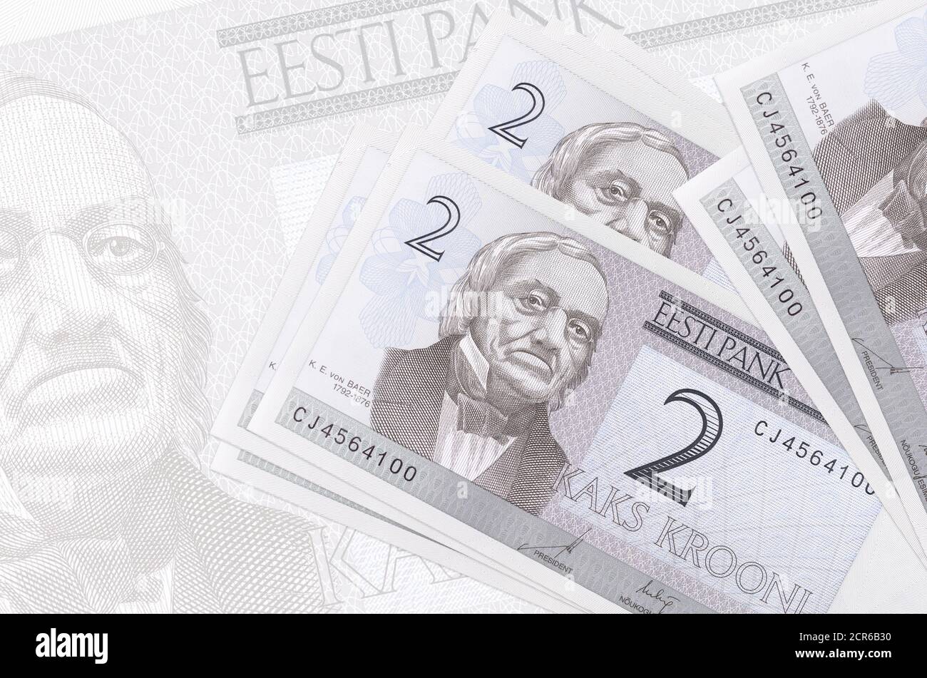 2 Estonian kroon bills lies in stack on background of big semi-transparent banknote. Abstract presentation of national currency. Business concept Stock Photo