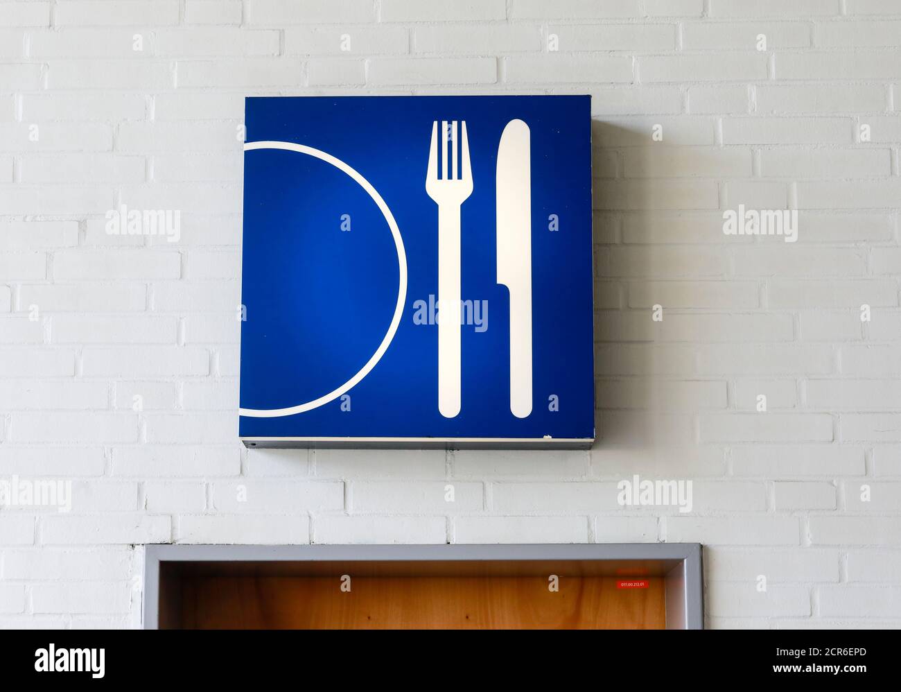 Hanover, Lower Saxony, Germany - Knife and fork with a plate symbol over a door at the Hanover Fair. Stock Photo