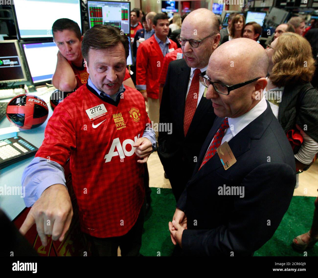 Floor official Thomas Facchine (L) of Getco Securities talks with Manchester United owners Avram (C) and Joel Glazer (R) following the start of trading of Manchester United Ltd following its initial public offering on the floor of the New York Stock Exchange, August 10, 2012. Shares in Manchester United priced below expectations and were essentially flat in early trading on Friday, a disappointing stock market debut for the world's most famous soccer club and most valuable sporting team. REUTERS/Brendan McDermid (UNITED STATES - Tags: BUSINESS SPORT SOCCER) Stock Photo