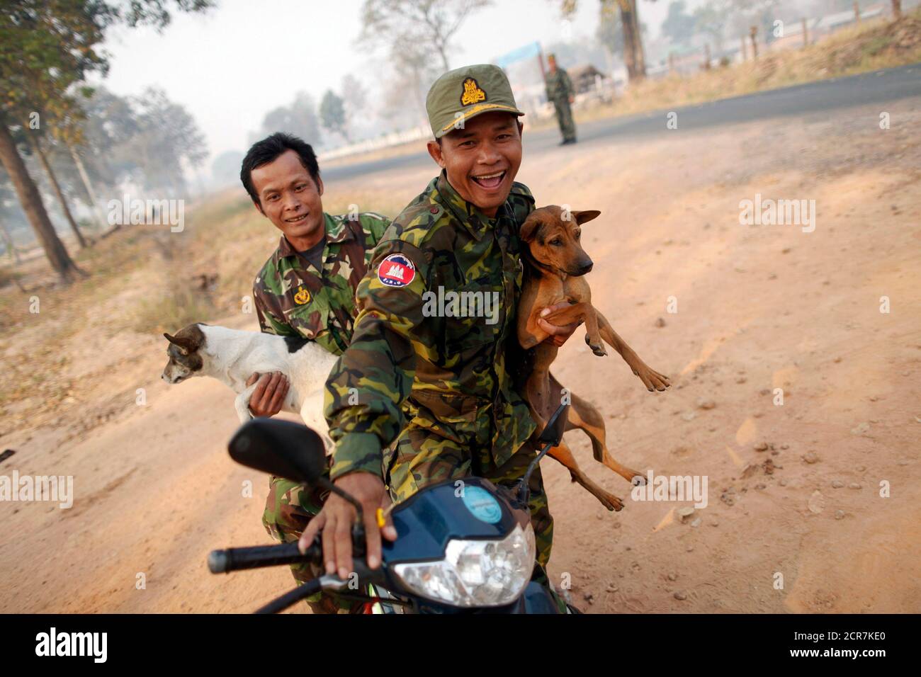 Cambodian soldiers carry dogs they found near the 11th-century Preah Vihear temple on the border between Thailand and Cambodia February 8, 2011. Thai and Cambodian troops stood on high alert on Tuesday after clashing in disputed jungle around the 900-year-old mountaintop Hindu temple, as both sides face intense regional diplomatic pressure to lay down arms.     REUTERS/Damir Sagolj (CAMBODIA - Tags: POLITICS MILITARY ANIMALS) Stock Photo