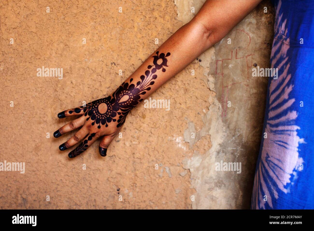 A woman shows off her finished tattoos done in the Chadian style at henna  tattoo artist Salimatou Lamidou's house and studio in Niamey September 20,  2013. In Niger, women pay up to