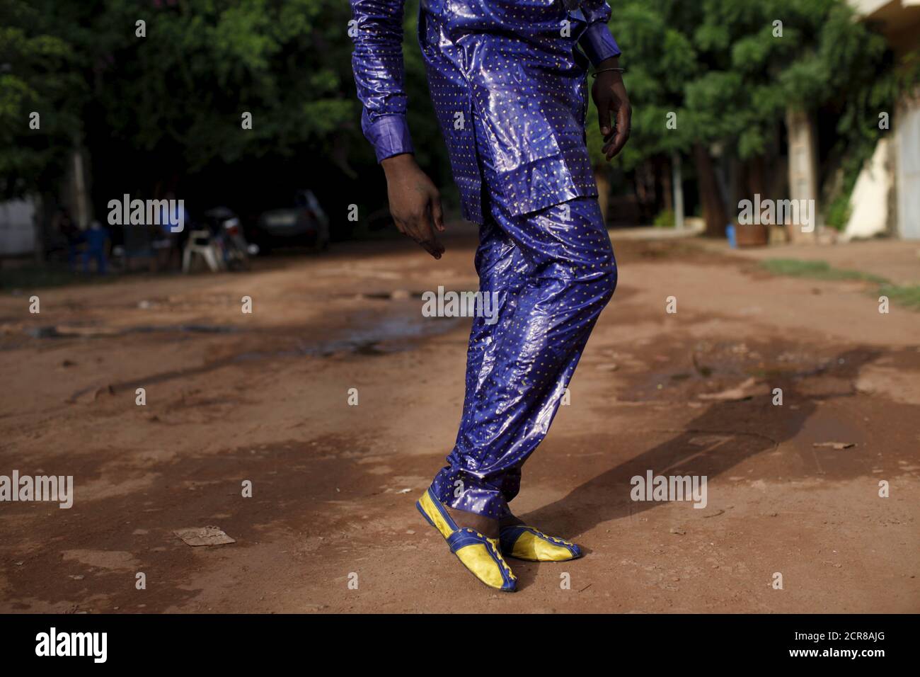 Bazin designer Baba Sereme poses for a picture in a bazin outfit he dyed,  in front of his home in Bamako, Mali, October 8, 2015. Gasps of delight  filled the convention hall