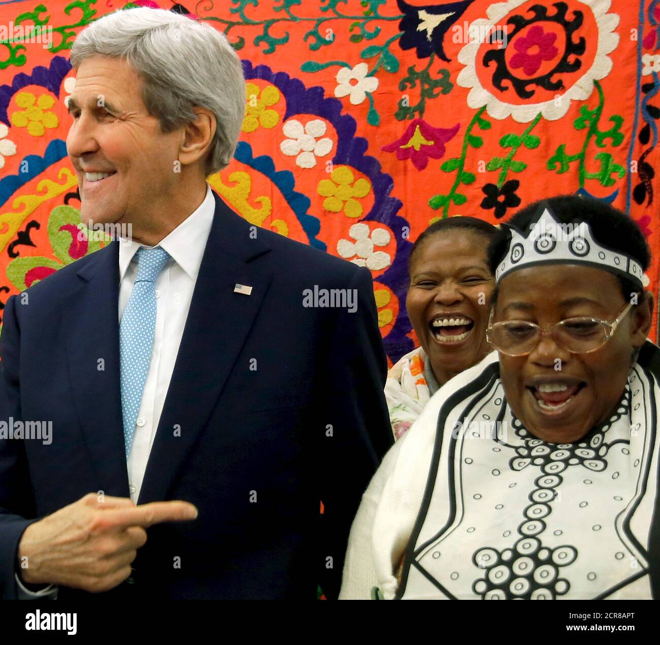 In a bit of wordplay U.S. Secretary of State John Kerry (L) crowns Jennifer  Ngwere (R) "queen bee" as she tries on a princess crown for little girls  while showing Kerry welcome