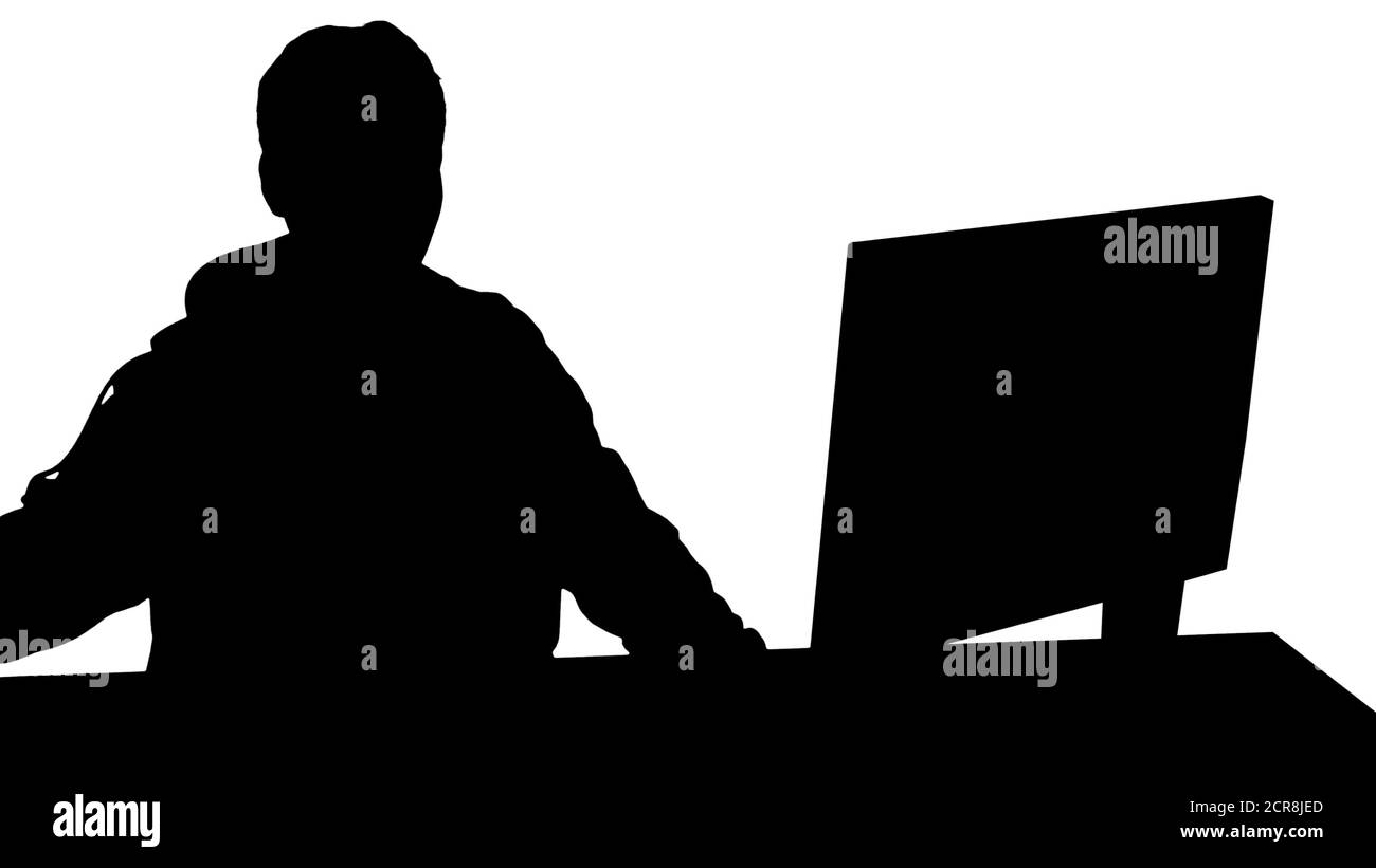Silhouette Gamer guy with headphones playing video games on comp Stock Photo