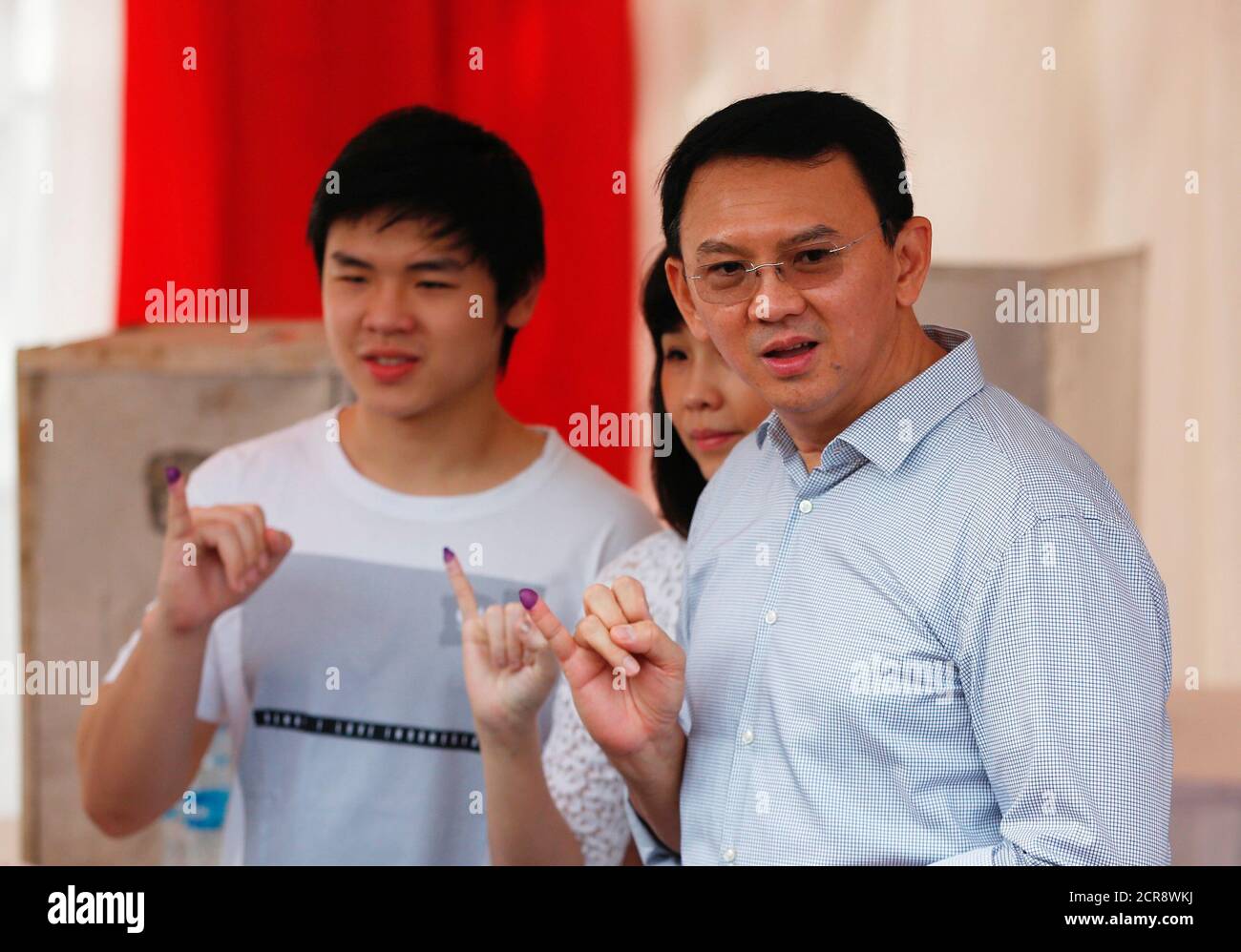 Incumbent Governor Basuki Ahok Tjahaja Purnama Holds Up His Ink Stained Finger Along With His Wife Veronica Tan And His Son Nicholas L After Casting His Vote The Jakarta Governor Election In