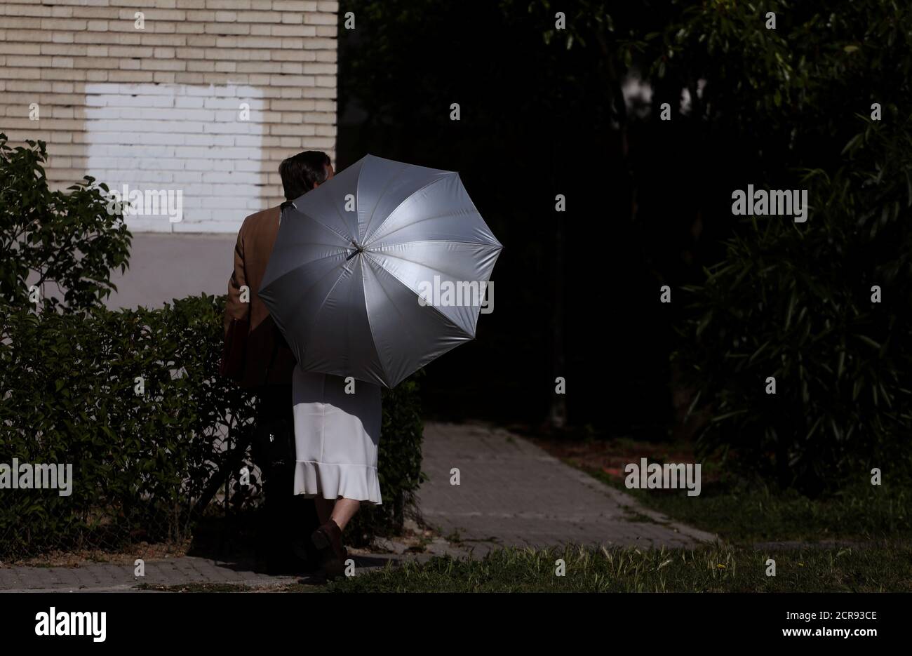 A woman shields from the sun with an umbrella during a sunny day in Madrid, Spain, May 23, 2018. REUTERS/Sergio Perez Stock Photo