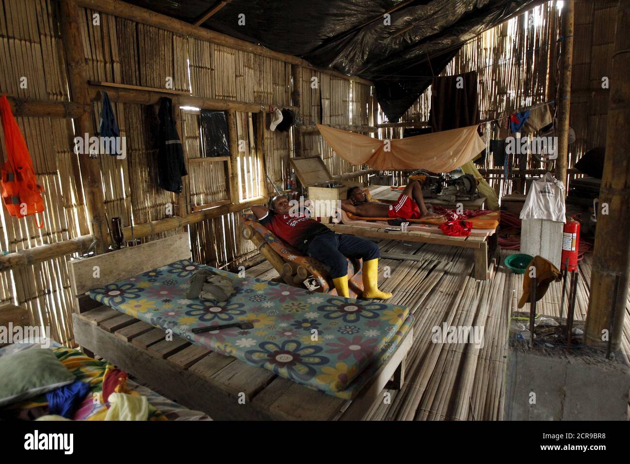 Workers of the Cofan indigenous people rest in a house in the Quichua community at Dureno, Ecuador, March 26, 2016.    REUTERS/Guillermo Granja Stock Photo