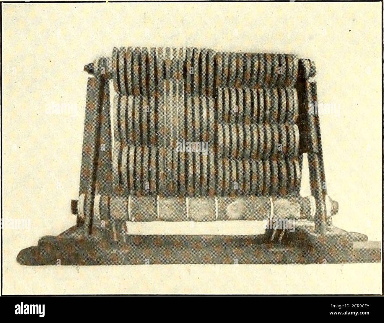 . Electric railway journal . forced open 1/16 in. and the grid is clamped to the jigwith a screw clamp, to provide for contraction in cooling.After the weld has been made and the cast iron hascooled to a dull red heat the clamp is removed to preventbreakage by contraction. An accompanying illustration shows two jigs withgrids mounted on them; that on the left side having thegrid lined up ready for welding, with the carbon moldand the screw clamp in place. The crack has been Vdout to permit puddling at the bottom and to save time.The jig on the right side contains a grid with the crackwelded. T Stock Photo