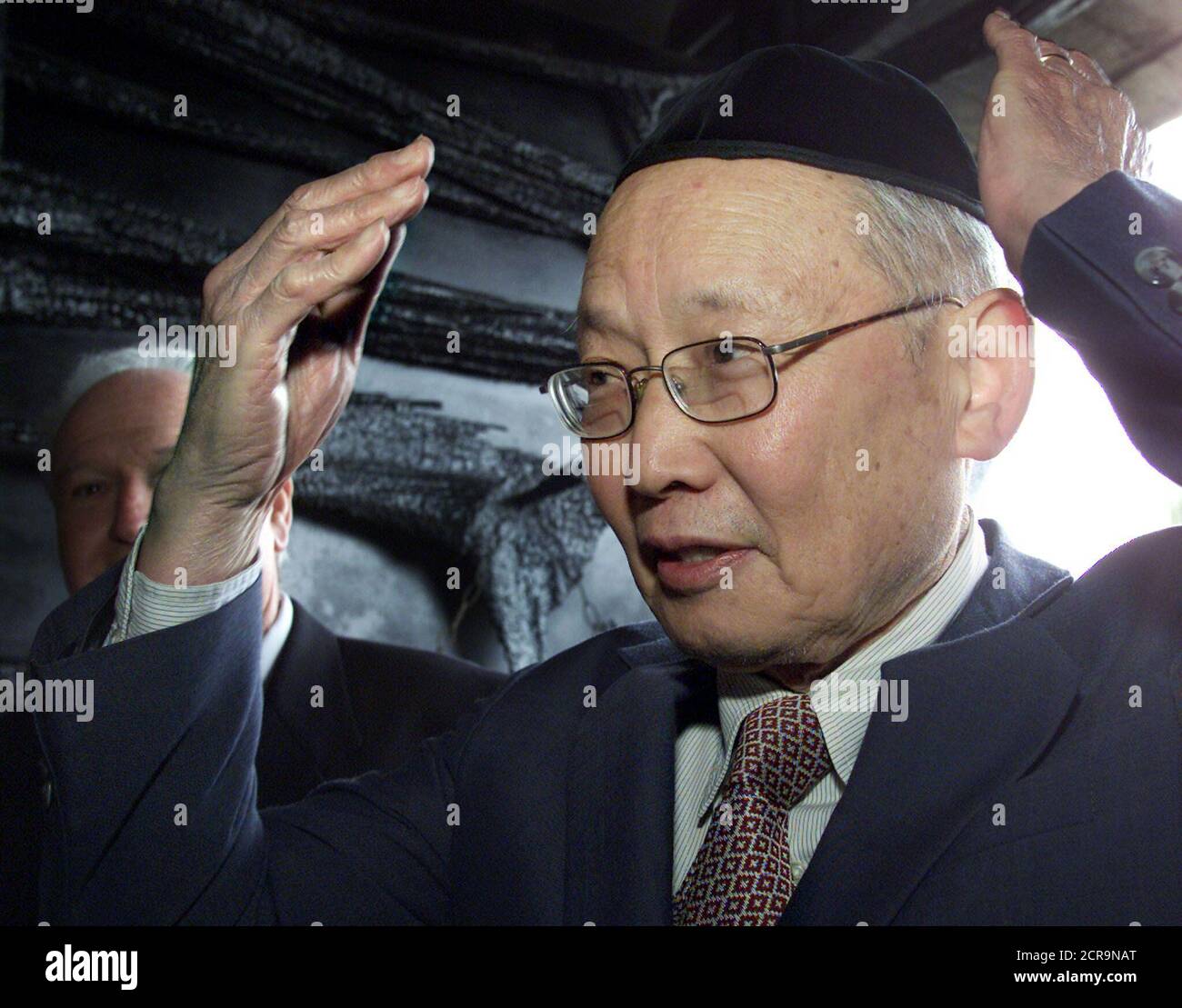 The late Chinese Consul-General in Vienna during 1938-40, Ho Feng Shan's, son Monto places a 'yamulka', or Jewish skullcap, on his head as he enters the 'Hall of Remembrances' in the Yad Vashem Holocaust Memorial complex during a ceremony in Jerusalem January 23, 2001. Monto, from Pittsburgh, PA and Taiwan, and his sister Manli received the 'Righteous Among The Nations' award on behalf of their father who saved hundreds if not thousands of Jews in Austria during the Nazi Holocaust. Ho Feng Shan issued exit visas to Shanghai to all Jews requesting them in order that they could leave Austria. Sh Stock Photo