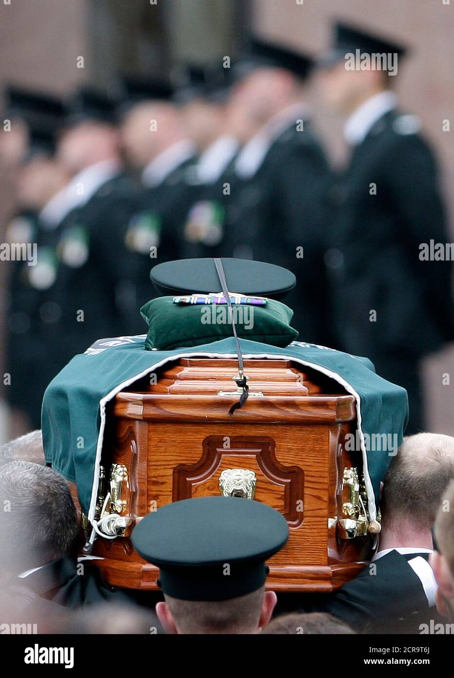 Police officers carry the coffin of Stephen Carroll into St Therese's