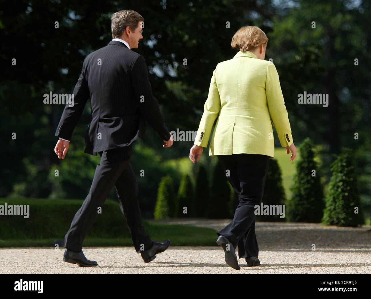 German Chancellor Angela Merkel (R) and Foreign Minister and Vice-Chancellor Guido Westerwelle leave a press briefing to attend a meeting with leading representatives of the economy and trade unions at the government guest house Schloss Meseberg, some 70 kilometres (43.5 miles) north of Berlin, June 18, 2010. REUTERS/Thomas Peter  (GERMANY - Tags: POLITICS) Stock Photo