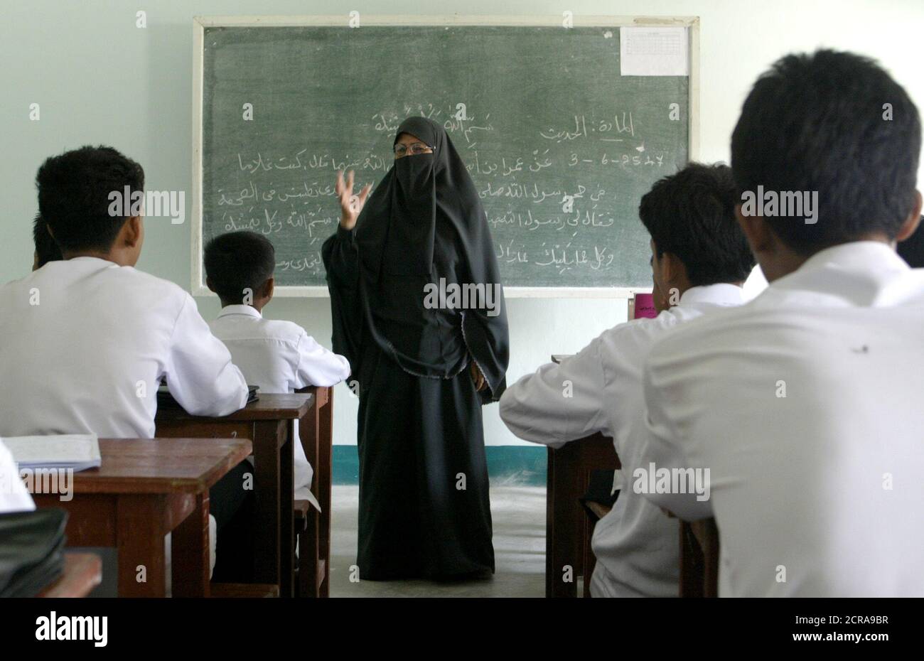 A Muslim woman teaches Thai students at a Muslim religious school in Narathiwat province, 1,200 km (750 miles) south of Bangkok on June 4, 2004. After five months of violence that has killed more than 200 people, Thailand is still groping to find the cause and develop a strategy to end the unrest in its mainly Muslim south, analysts say. Picture taken June 4, 2004. REUTERS/Sukree Sukplang  SS/TW Stock Photo
