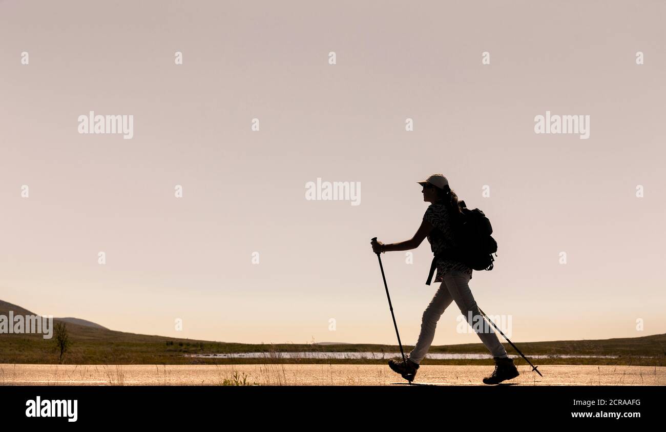 Woman with backpack while hiking Stock Photo - Alamy