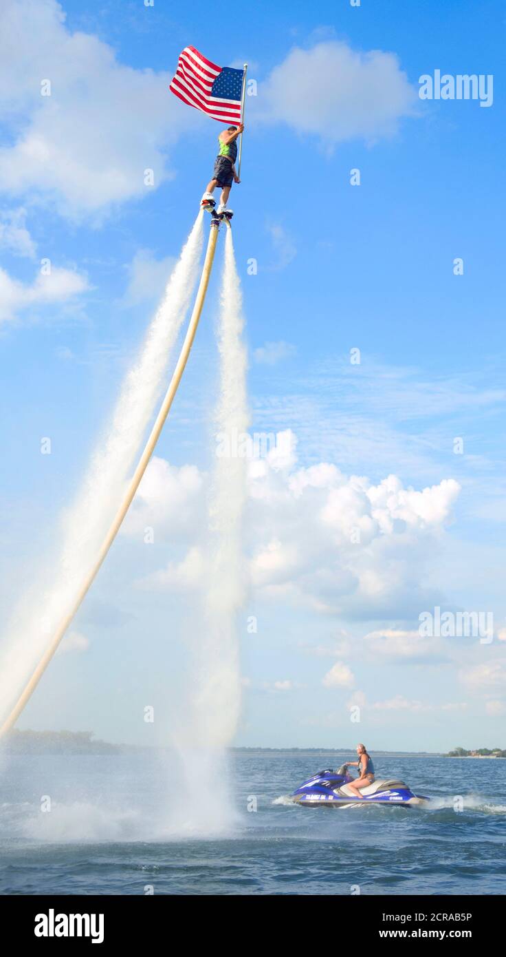 Rocket Man flying on a Jet Fly Board at Lake Arlington ,Texas and holding an American Flag. Stock Photo