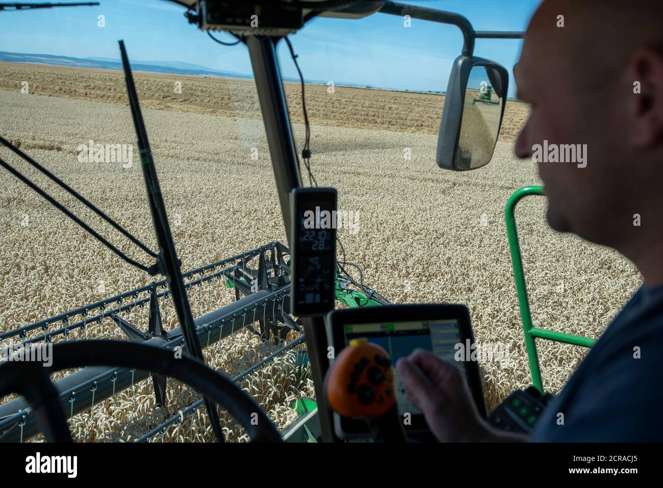 Cockpit of a combine harvester, driver, harvest of winter wheat Stock Photo