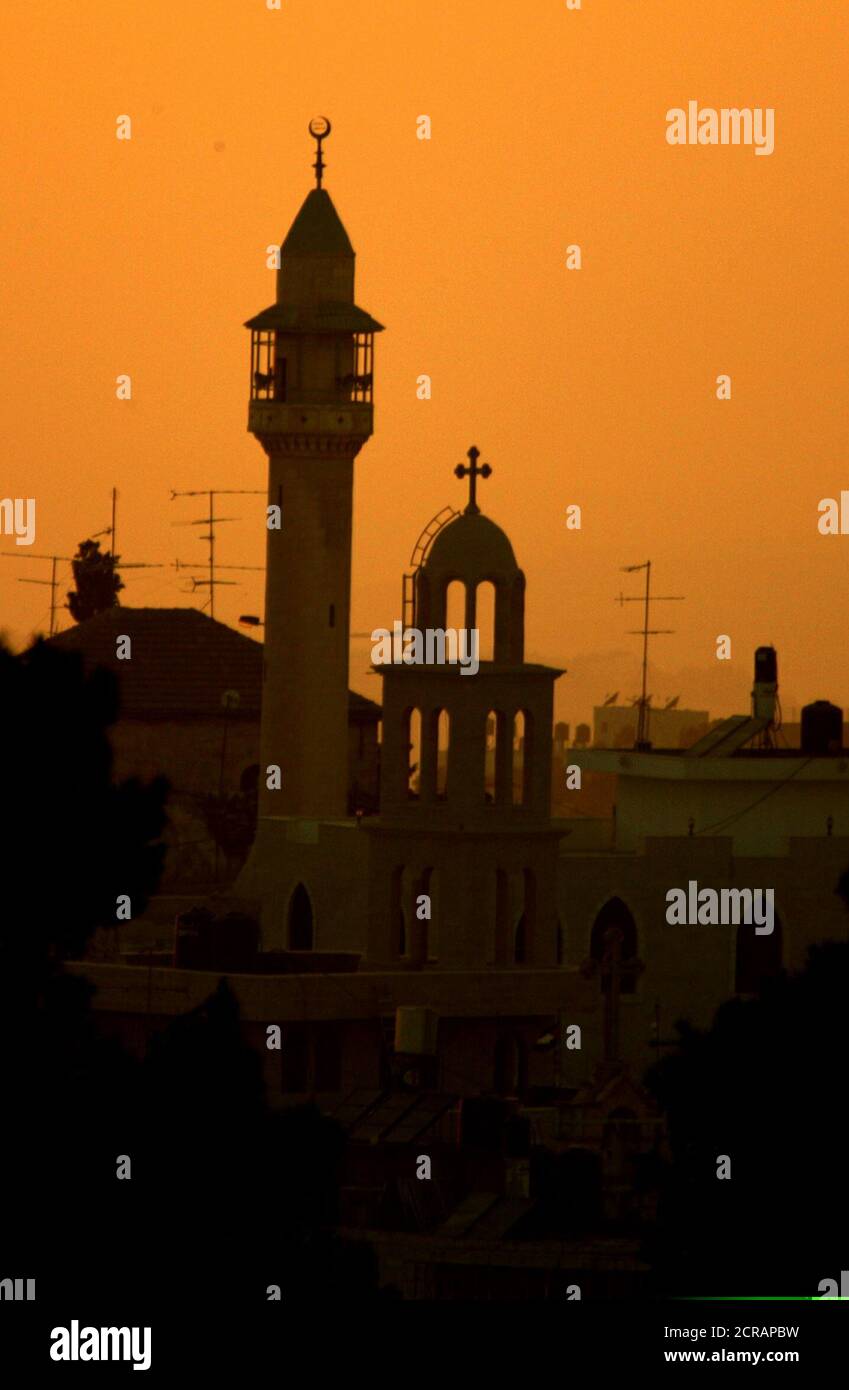A minaret of a mosque is seen beside an Orthodox Church near the Layaly Al Balad (City Nights) festival venue for dance and traditional music in the West Bank City of Ramallah August 14, 2003. Three groups of performers, two Palestinian and one Israeli-Arab, performed over three nights at the First Ramallah Group Club. The concerts were organised by Palestinian intellectuals to revive the once bustling summer life of the city. REUTERS/Osama Silwadi PP03080068  OS/SN Stock Photo