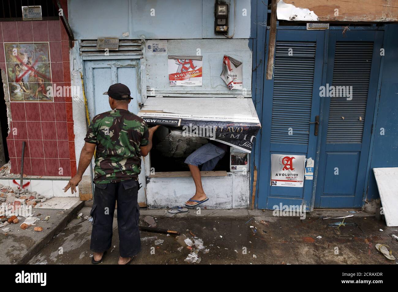 Men enter a shop to gain access to a dwelling behind to remove scrap  building materials in the Kalijodo red-light district in Jakarta, Indonesia  February 26, 2016. Indonesia aims to shutdown all